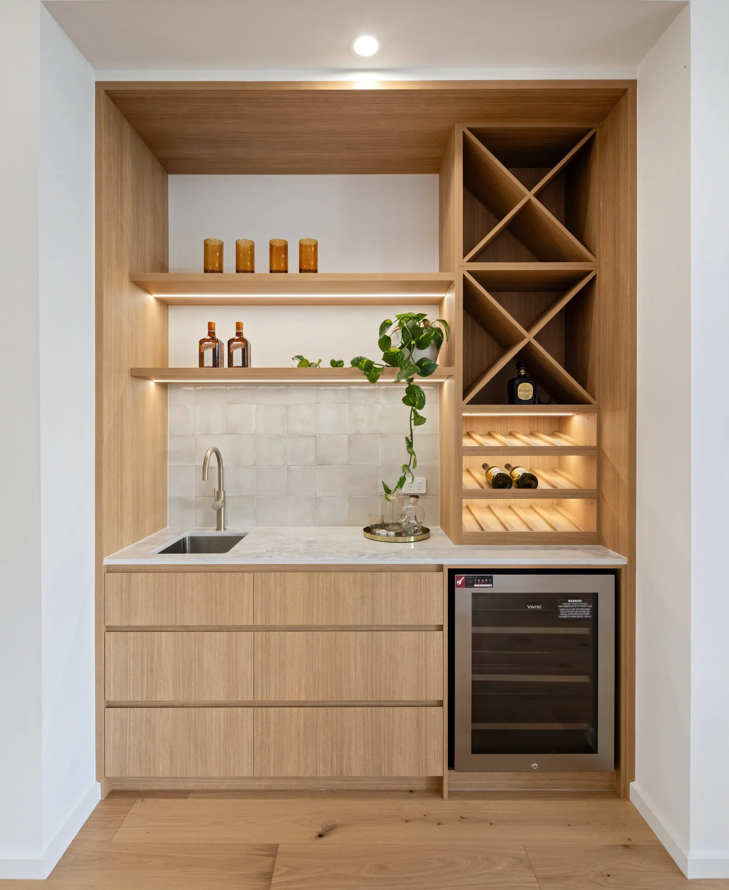 Timber bar joinery with open shelving, wine storage and integrated lighting